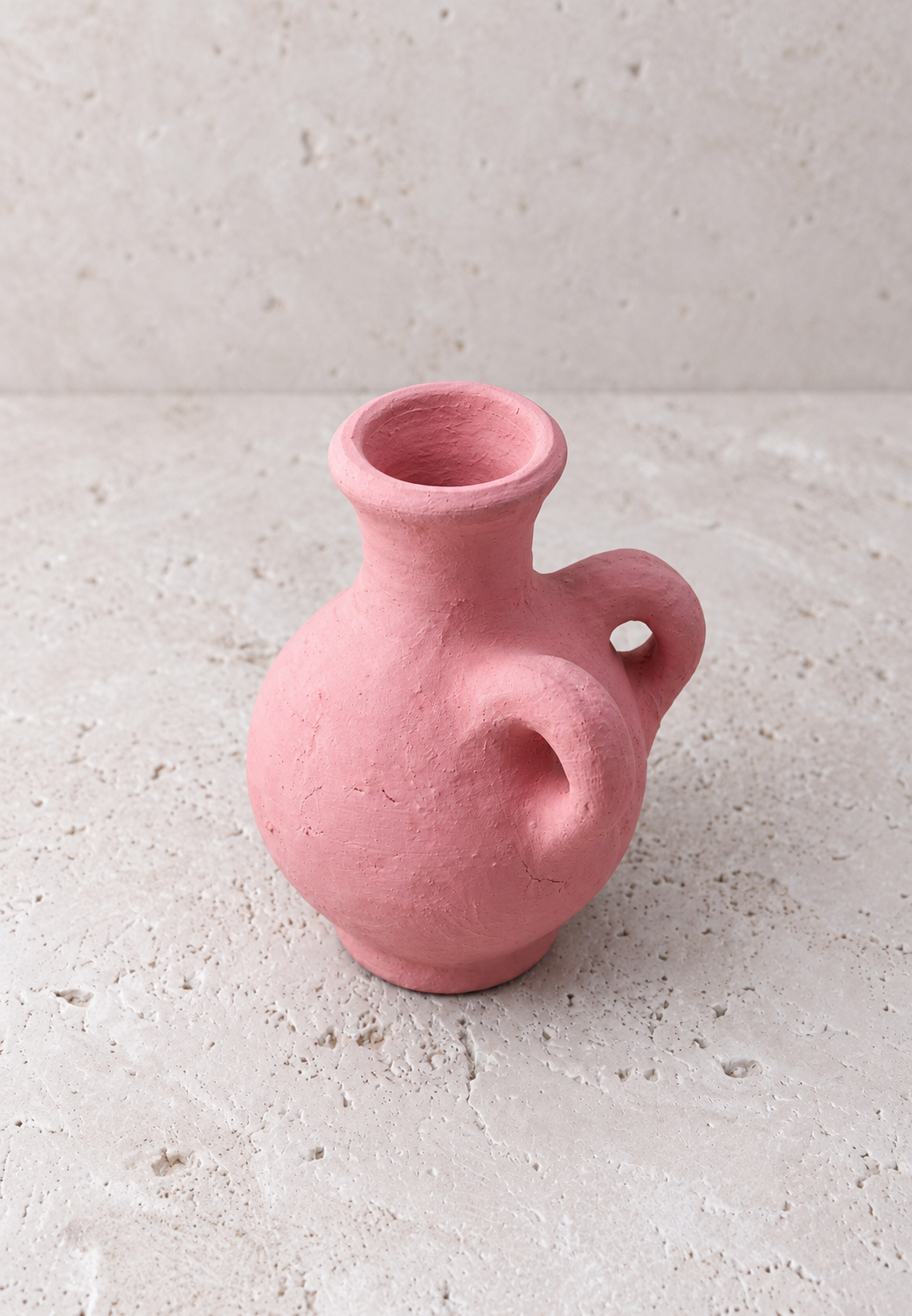 Détail de la surface mate et sablée rose corail du vase amphore